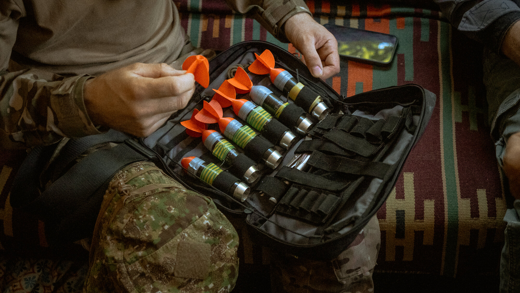 A member of Azov Special Operations Regiment (SSO) reconnaissance section displays 40mm grenades converted into home-made bombs to be dropped from a commercial drone, in the southern Zaporizhia sector / 
У Запоріжжі розвідник полку ССО «Азов» демонструє 40-мм гранати, перероблені на бомби для скидання з комерційного дрона. 
