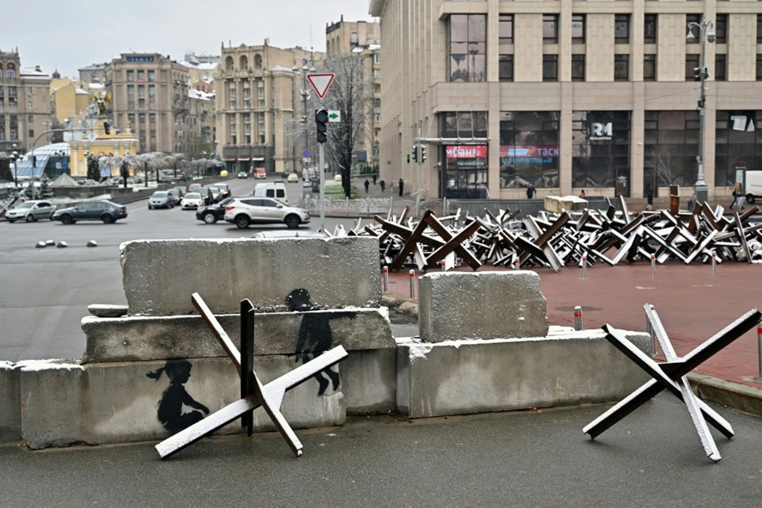 This photograph taken on November 17, 2022, shows a piece by British street artist Banksy on an anti-tank constructions at Independence Square in Kyiv.