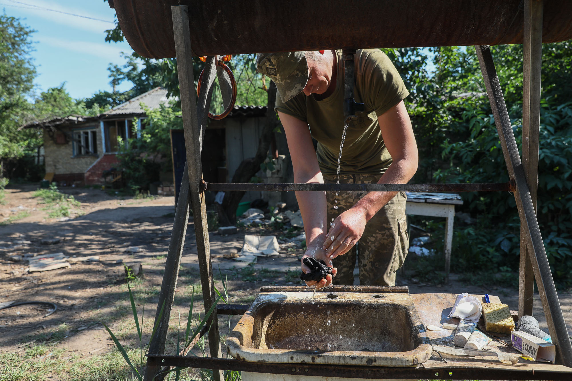 A Ukrainian soldier washes his socks near frontline barracks in the town of Zaitseve on June 25