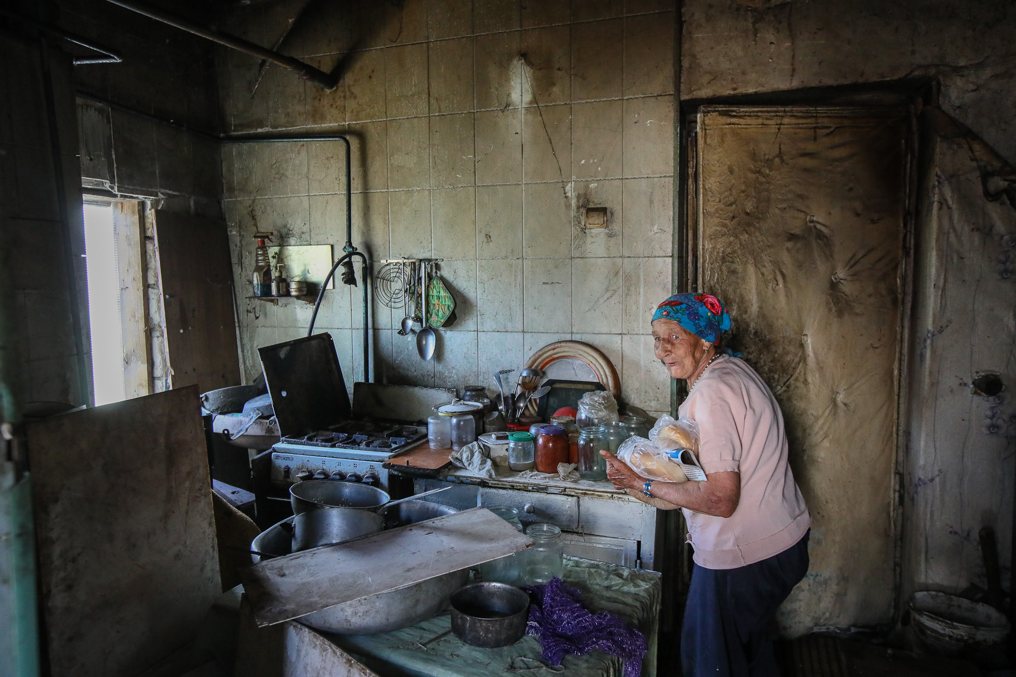Mariya Horpynych, a elderly local civilian, works about the house, pictured in the town of Opytne, eastern Ukraine, on June 12, 2019.