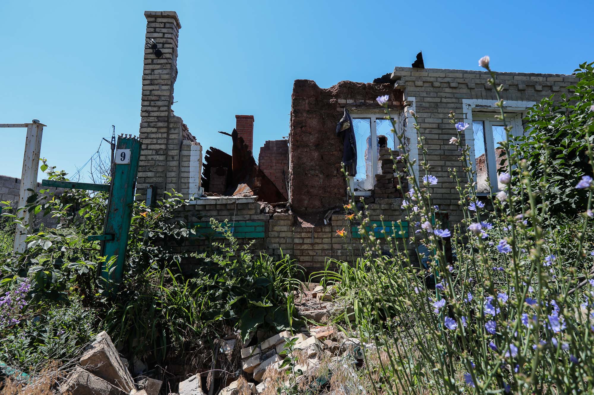 Ruins of a shelled house are seen in the Donbas frontline town of Zaitseve on June 25, 2018.