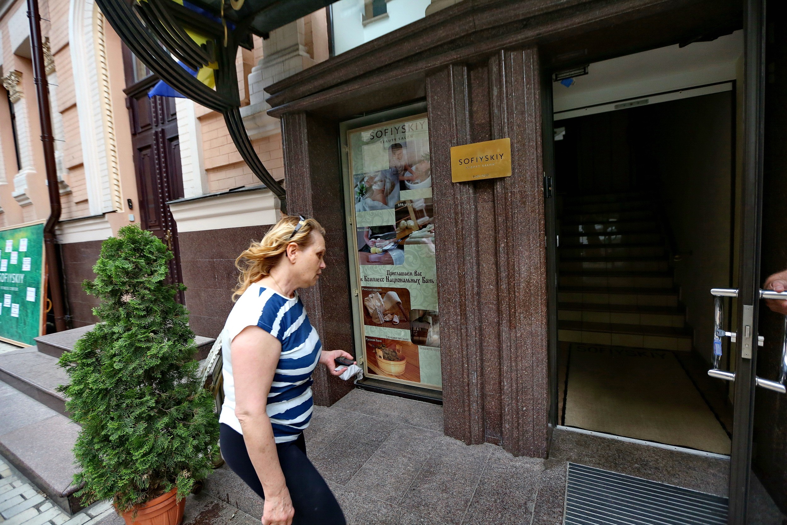 Iryna Ryabchenko, one of the owners of Sofiyskiy Fitness Centre, walks into one of the entrances of the fitness center in Kyiv on June 13.