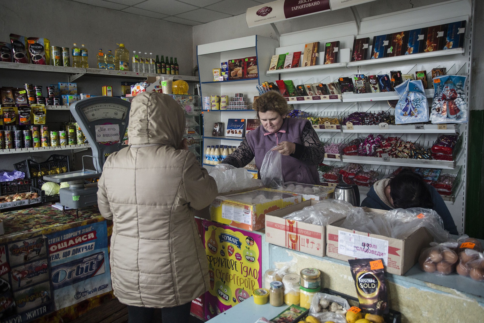 A woman buys products at a grocery shop in Verkhniotoretske town of Donetsk Oblast, located just in 12 kilometers from separatist-held Yasynuvata on Nov. 29.