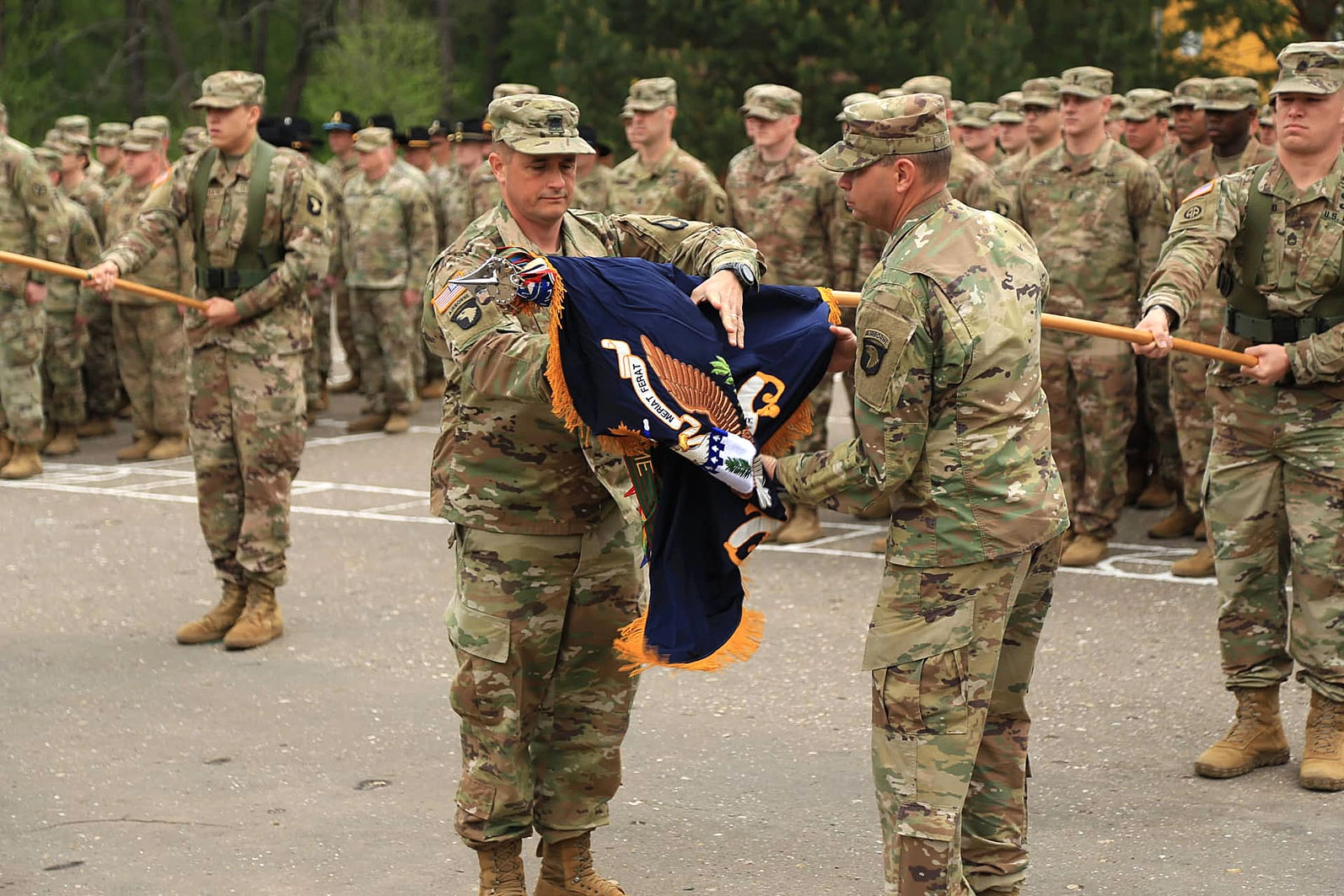 Servicemen of the U.S. Army 101st Division uncase their colors during the transfer of authority ceremony of the JMTG-U training mission at the Yavoriv training range on May 2, 2019.