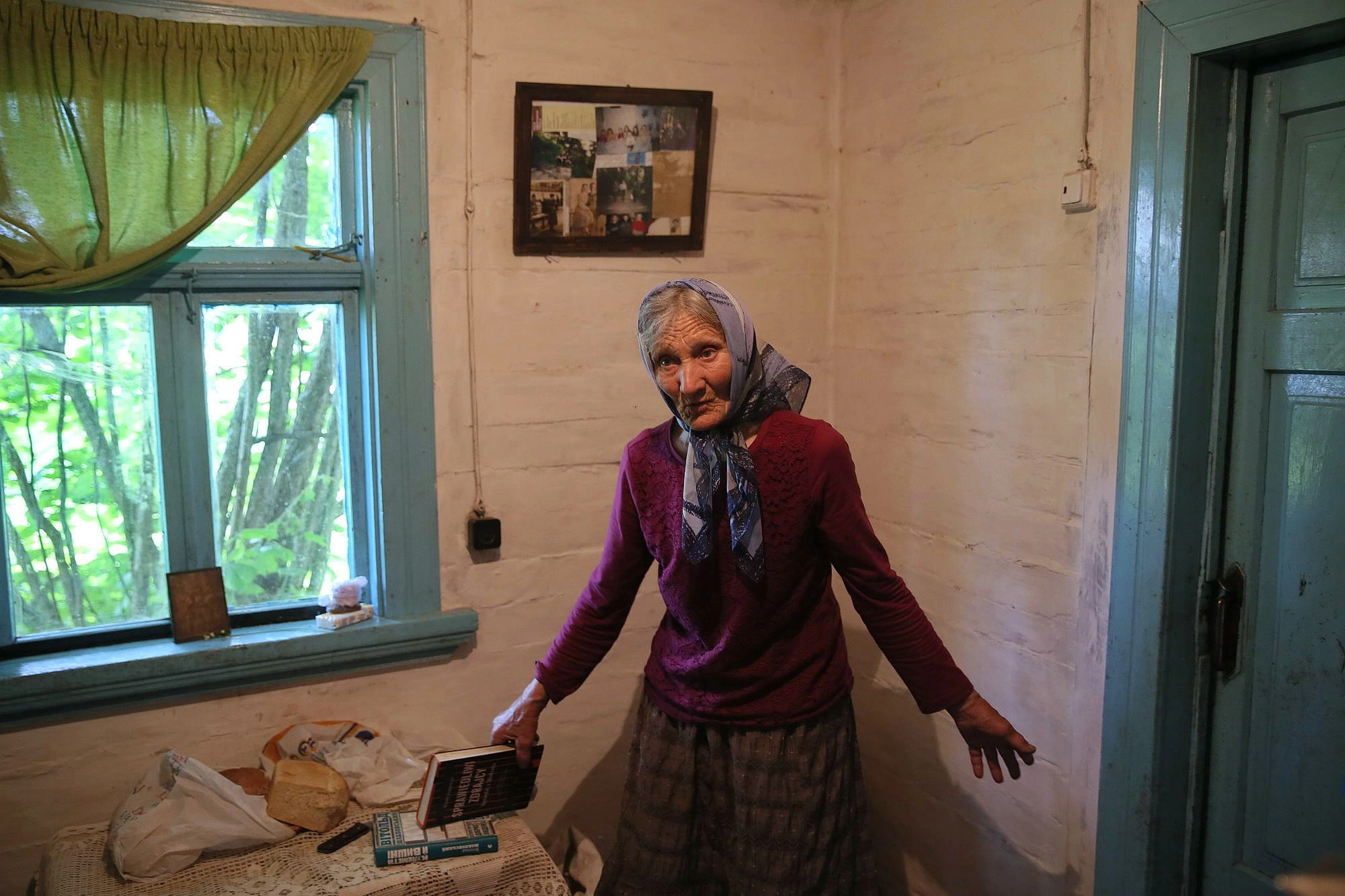 Oleksandra Vaseiko holds a book by Witold Szablowski “Righteous Traitors. Neighbors from Volyn”, where she is one of main characters, in her house in the village of Sokil in Volyn Oblast.