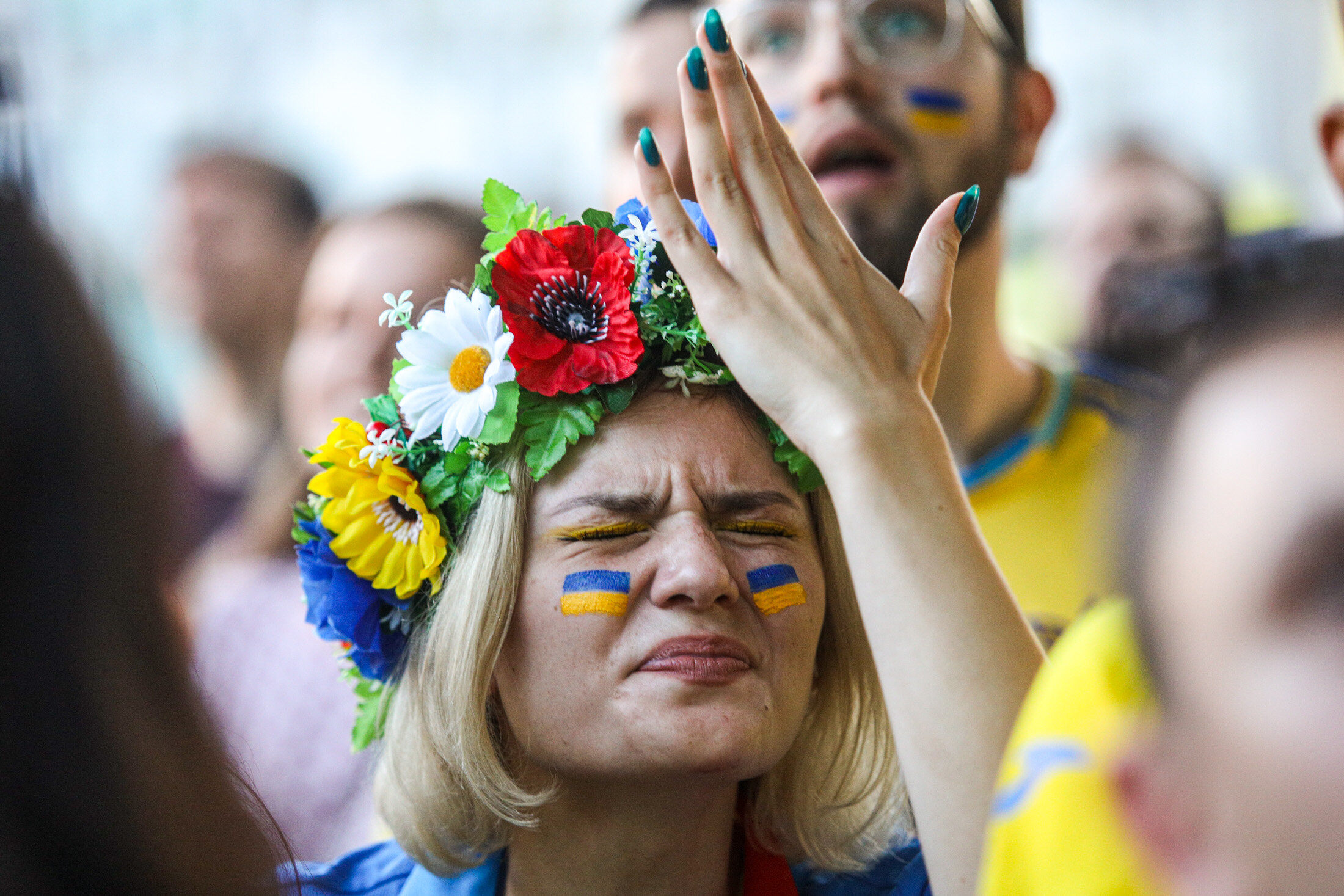 An Ukrainian supporter reacts ss she watches the  UEFA EURO 2020 Group C football match between Ukraine and Austria on a giant screen in the center of Kyiv on June 21, 2021.