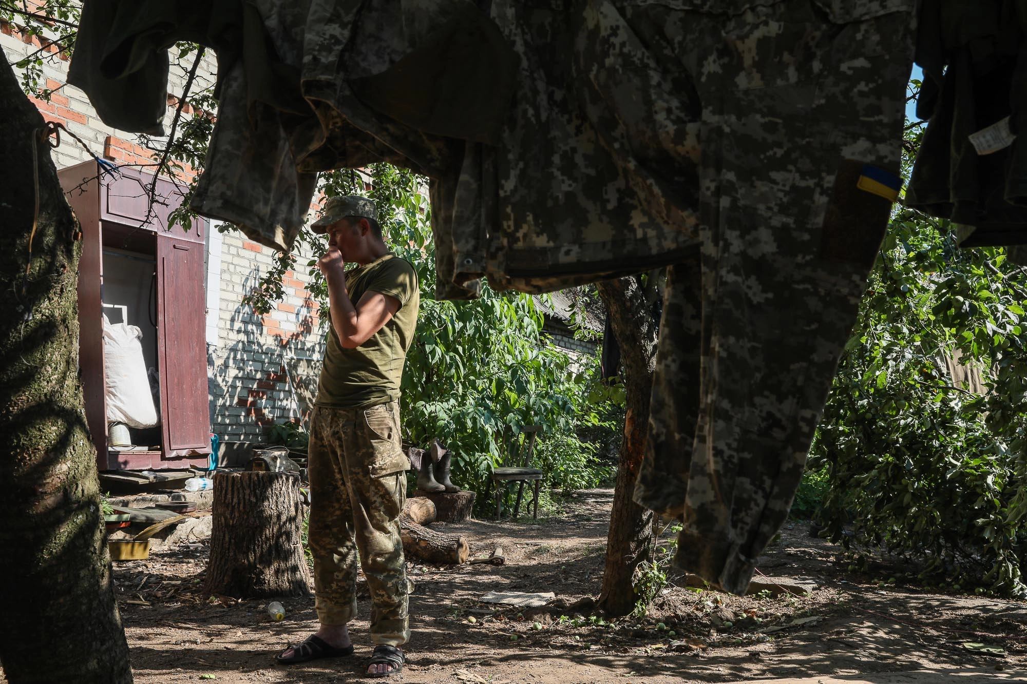 A Ukrainian soldier puts his washed uniform out to dry near a barrack in the town of Zaitseve on June 25