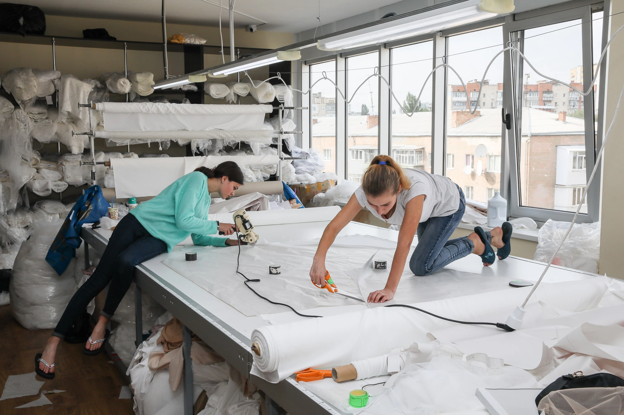 Seamstresses make measurements so that automatic equipment can cut off the necessary amount of fabric at a sewing plant located in the city of Khmelnytskyi on Sept. 11, 2018. 