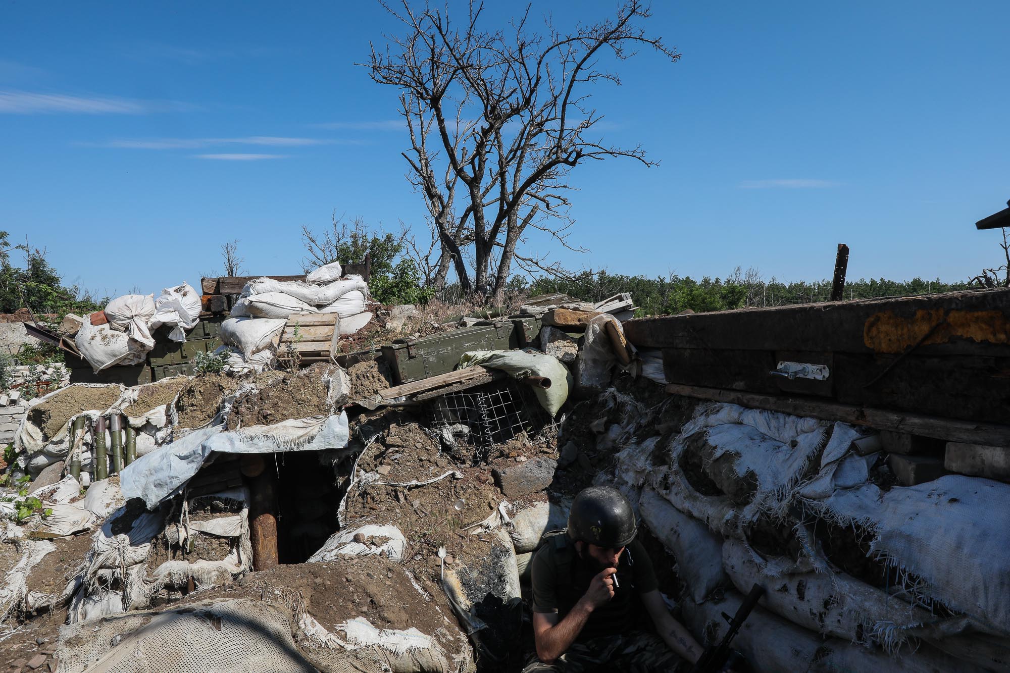 A Ukrainian soldier smokes at a frontline combat post in the town of Zaitseve on June 25