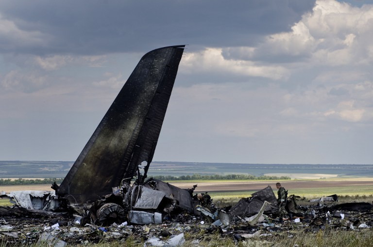Pro-Russian separatists look through the debris of an IL-76 transporter which was taken down by pro-Russian rebels on the outskirts of Lugansk June 14, 2014. 