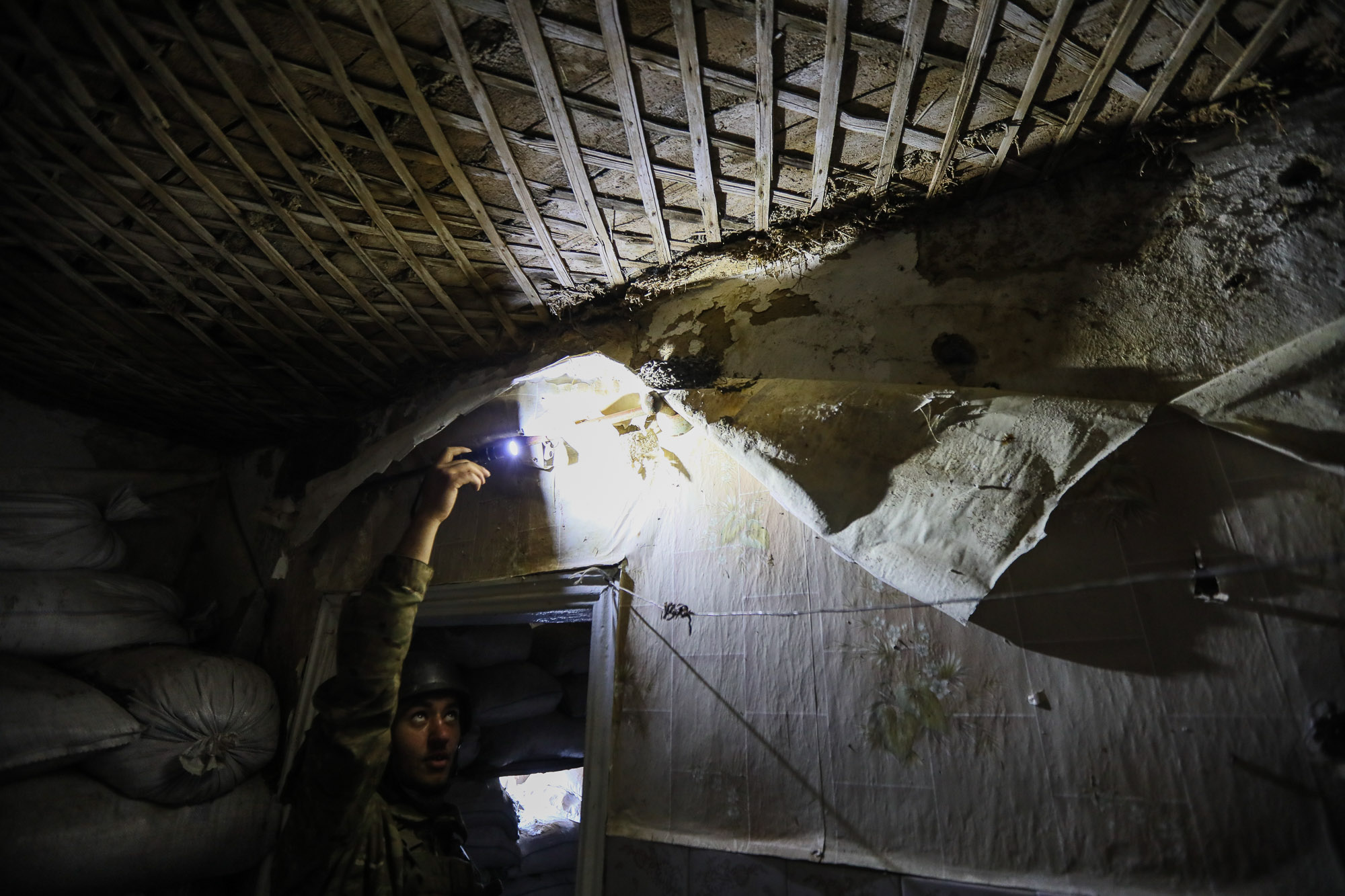 A Ukrainian soldier shines light on a bird nest at a combat post in a ruined house in the town of Zaitseve on June 25 
