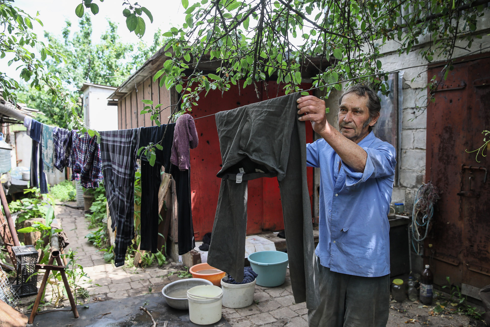 Oleksandr Suprun, a local civilian, hangs out his washing at his home in the town of Opytne on June 12, 2019.
