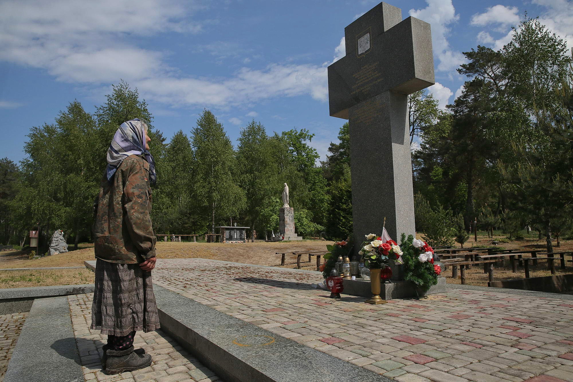 Oleksandra Vaseiko looks at a cross hoisted in commemoration of hundreds of Poles killed in the area in 1943 near her village of Sokil in Volyn Oblast.