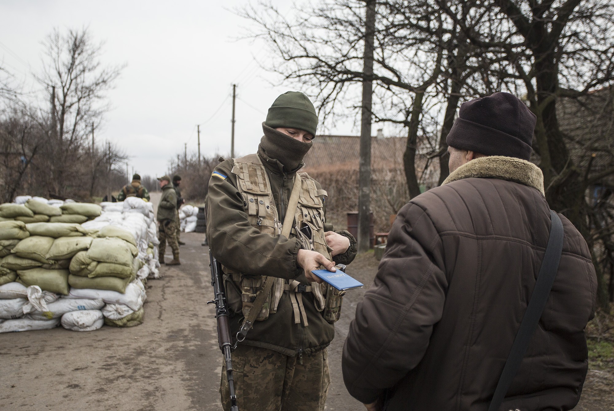 A Ukrainian soldier checks the passport of a man from Verkhniotoretske who is heading to the separatist-held zone on Nov. 29.