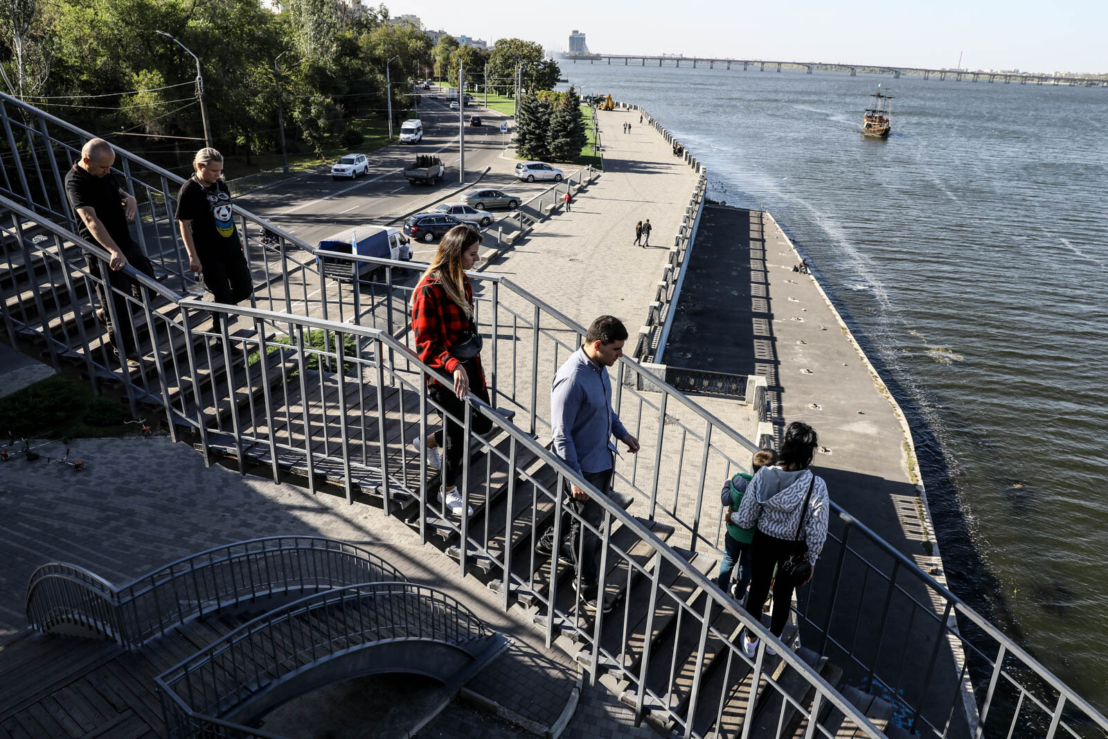 People exit a pedestrian bridge in Dnipro, on Oct. 6, 2020. The embankment along the Dnipro River is one of the locals&#8217; favorite places to relax.