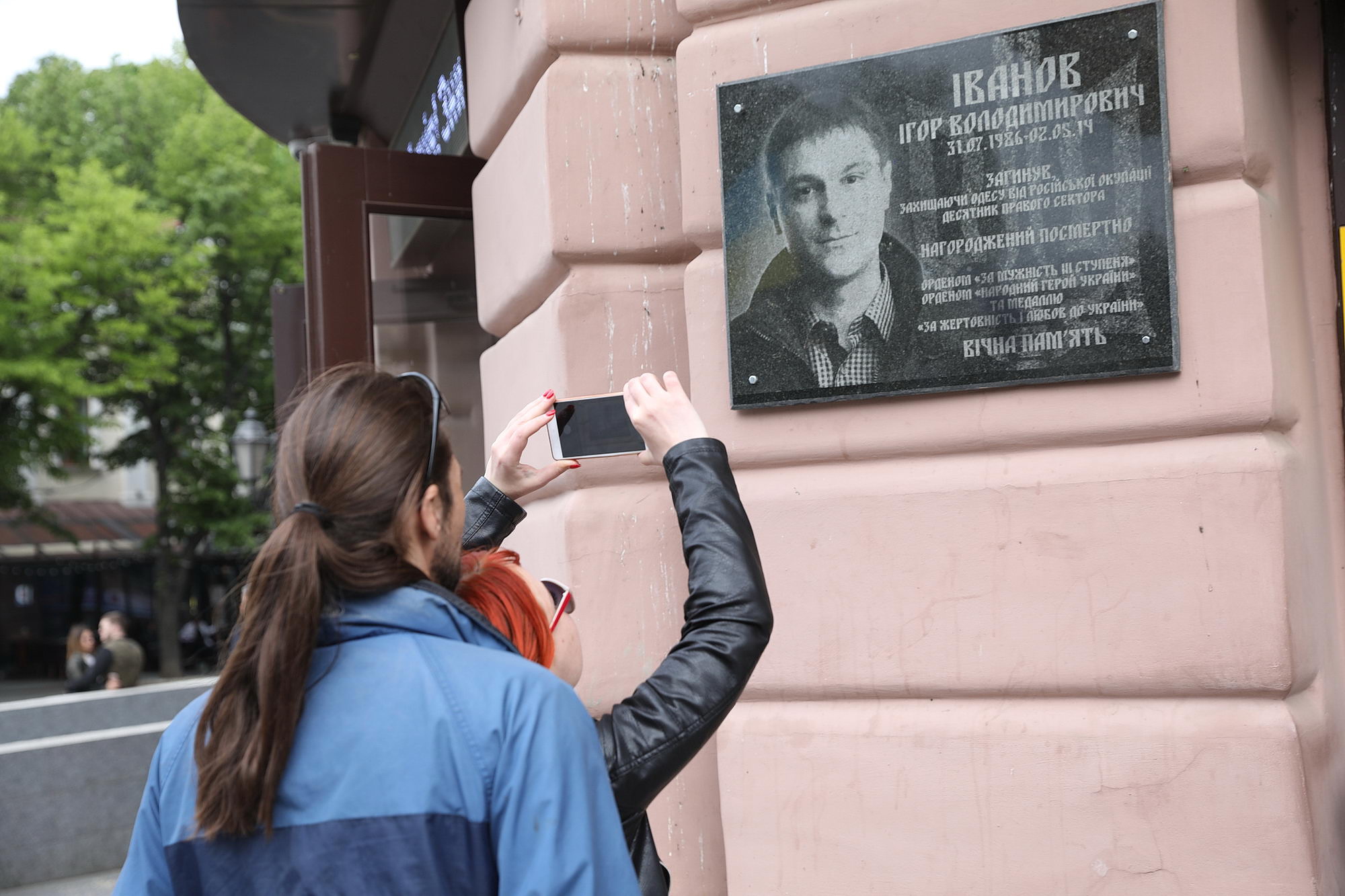A girl takes a photo of the memorial plaque to the activist of Right Sector Ihor Ivanov on May 10, 2019, in Odesa. Ivanov was one of two pro-Ukrainian activists who were killed in the street fights in Odesa on May 2, 2014. 