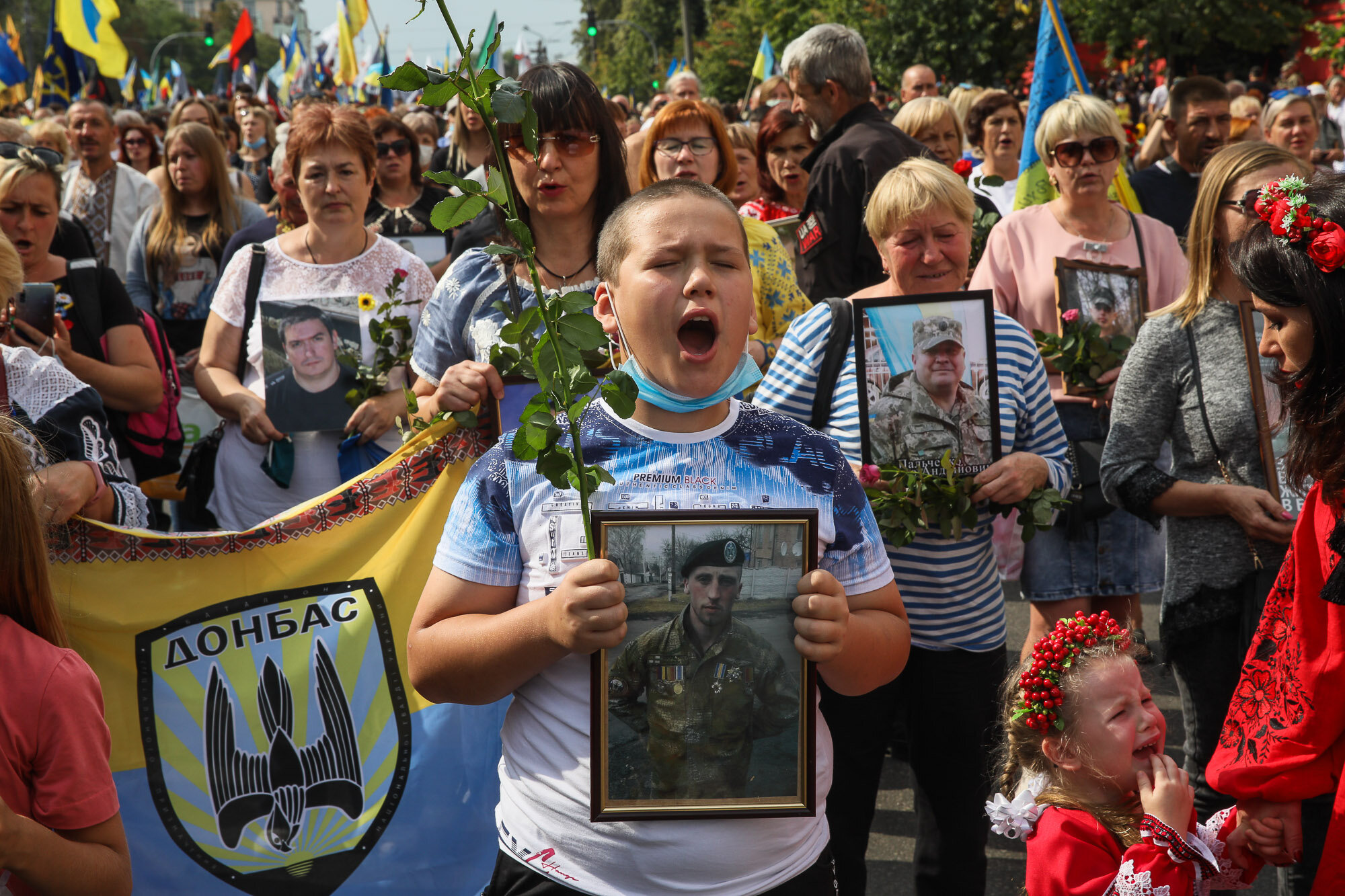 A boy chants as people carry portraits of fallen soldiers during the March of Defenders of Ukraine, an event that celebrated Ukraine&#8217;s Independence Day in Kyiv on Aug. 24, 2020.
