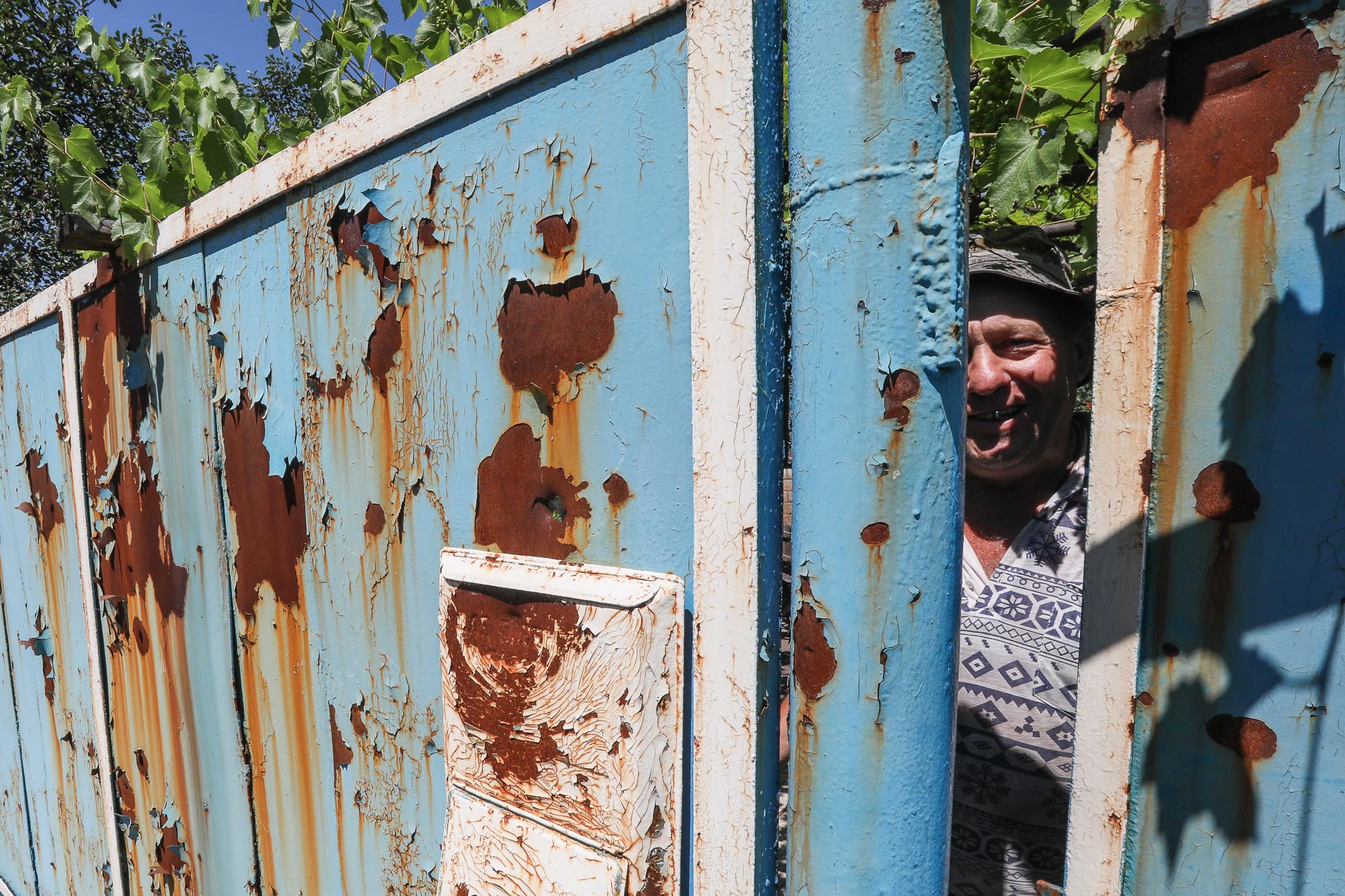 A Ukrainian civilian peeps out from behind a wicket in the town of Zaitseve on June 25