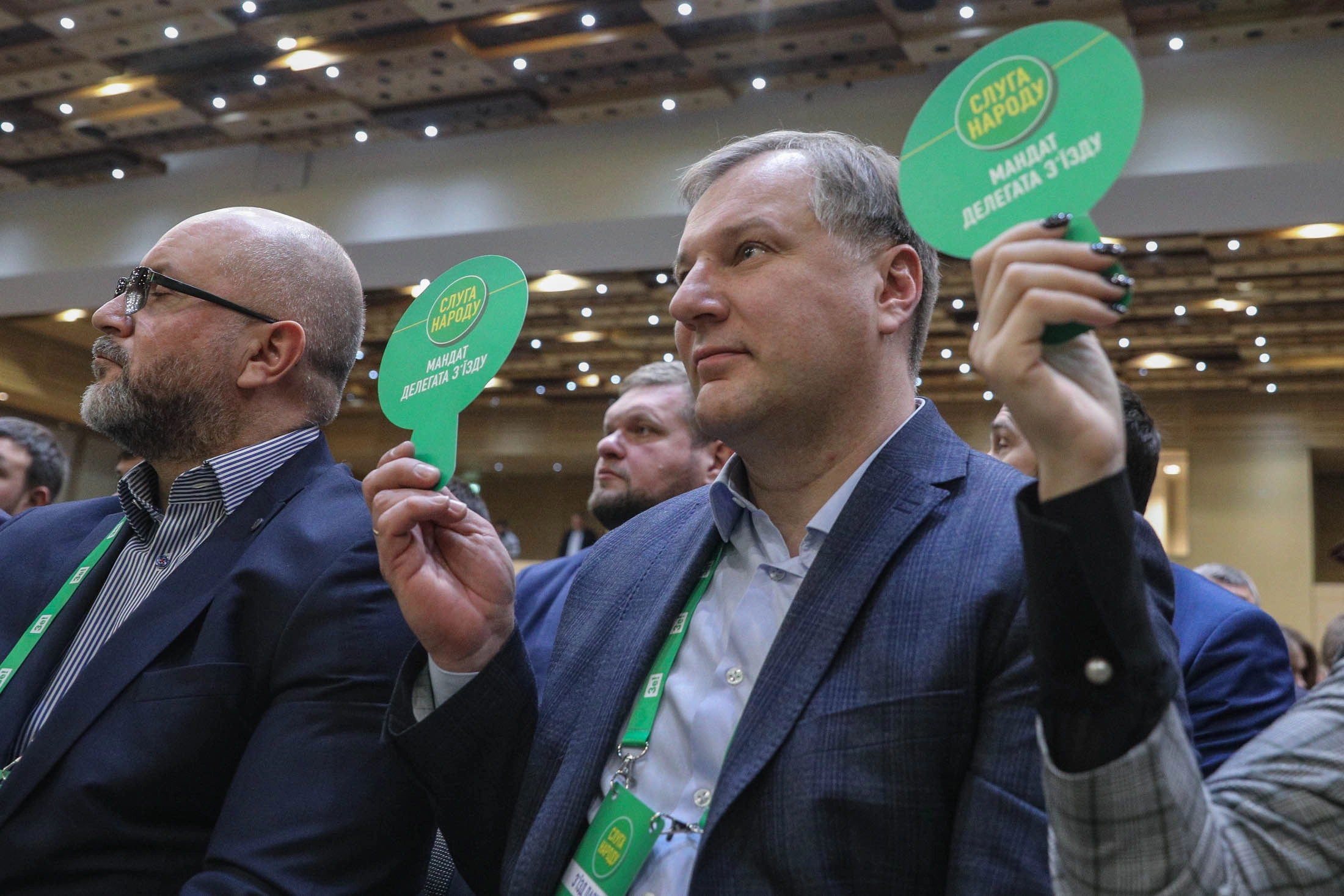 Lawmakers of the Servant of the People party raise their hands to vote during a party congress at the Parkovy convention center in Kyiv on February 15, 2020.