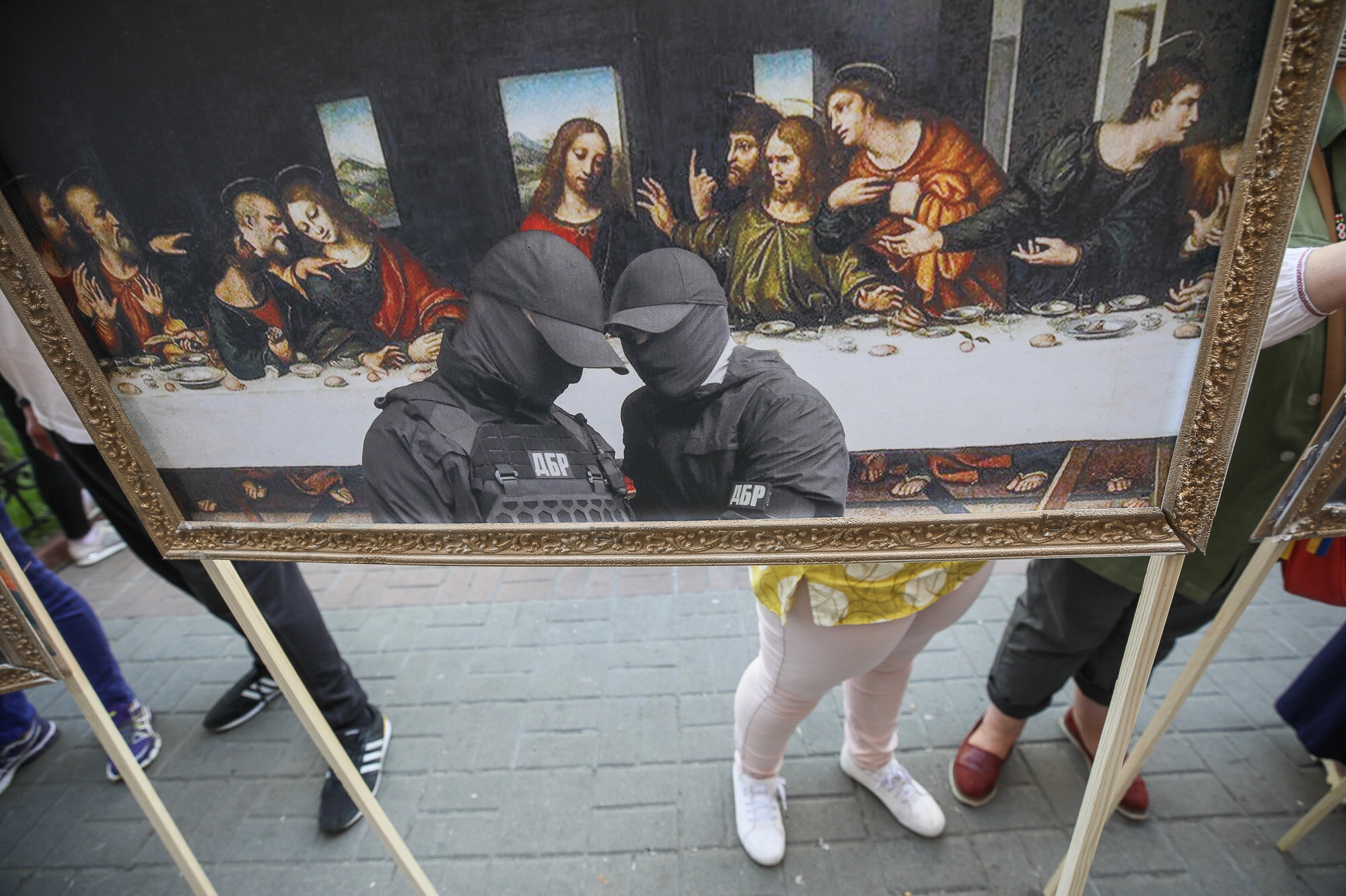 Activists and supporters of European Solidarity political party and Petro Poroshenko hold mockup pictures of classic art masterpieces with the faces of Prosecutor General Iryna Venediktova and President Volodymyr Zelensky during a rally in front of the State Investigation Bureau in downtown Kyiv on June 10, 2020.