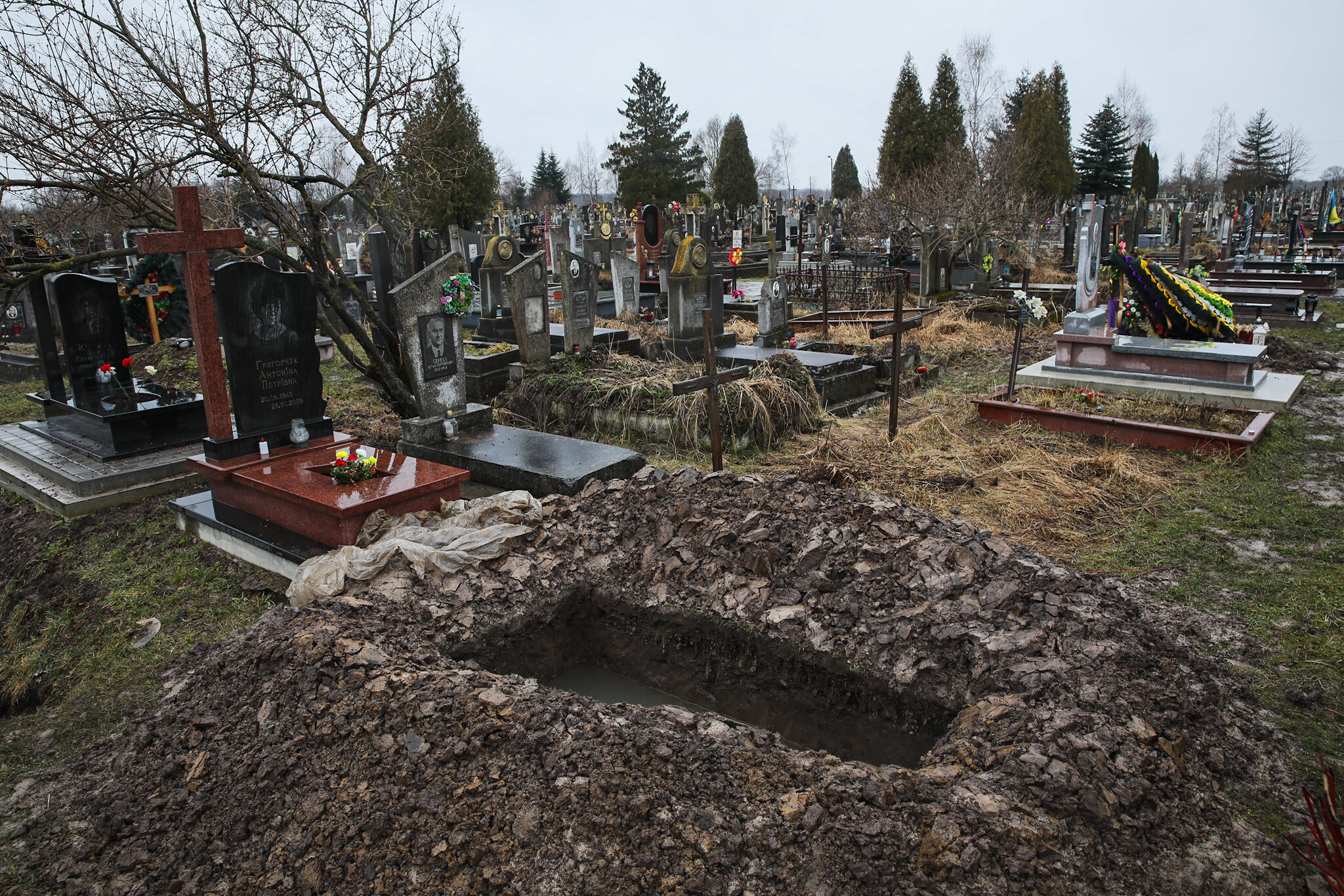 A fresh-dug grave is seen at the local cemetery in Kolomyia in Ivano-Frankivsk Oblast on March 16, 2021.