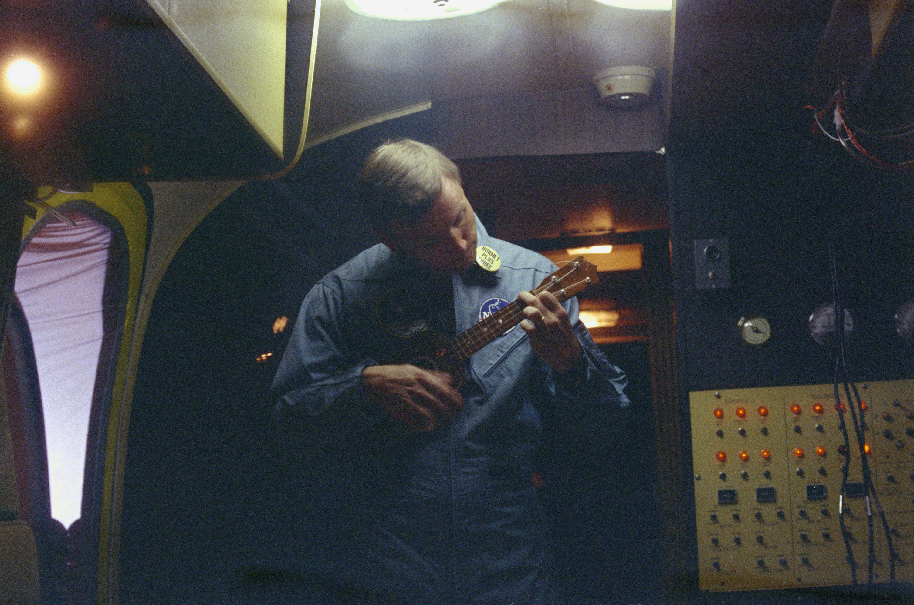 The first moonwalker Neil Armstrong plays ukulele inside a biological protection wagon on board of USS Hornet shortly after being recovered in the Pacific Ocean on July 24, 1969. 