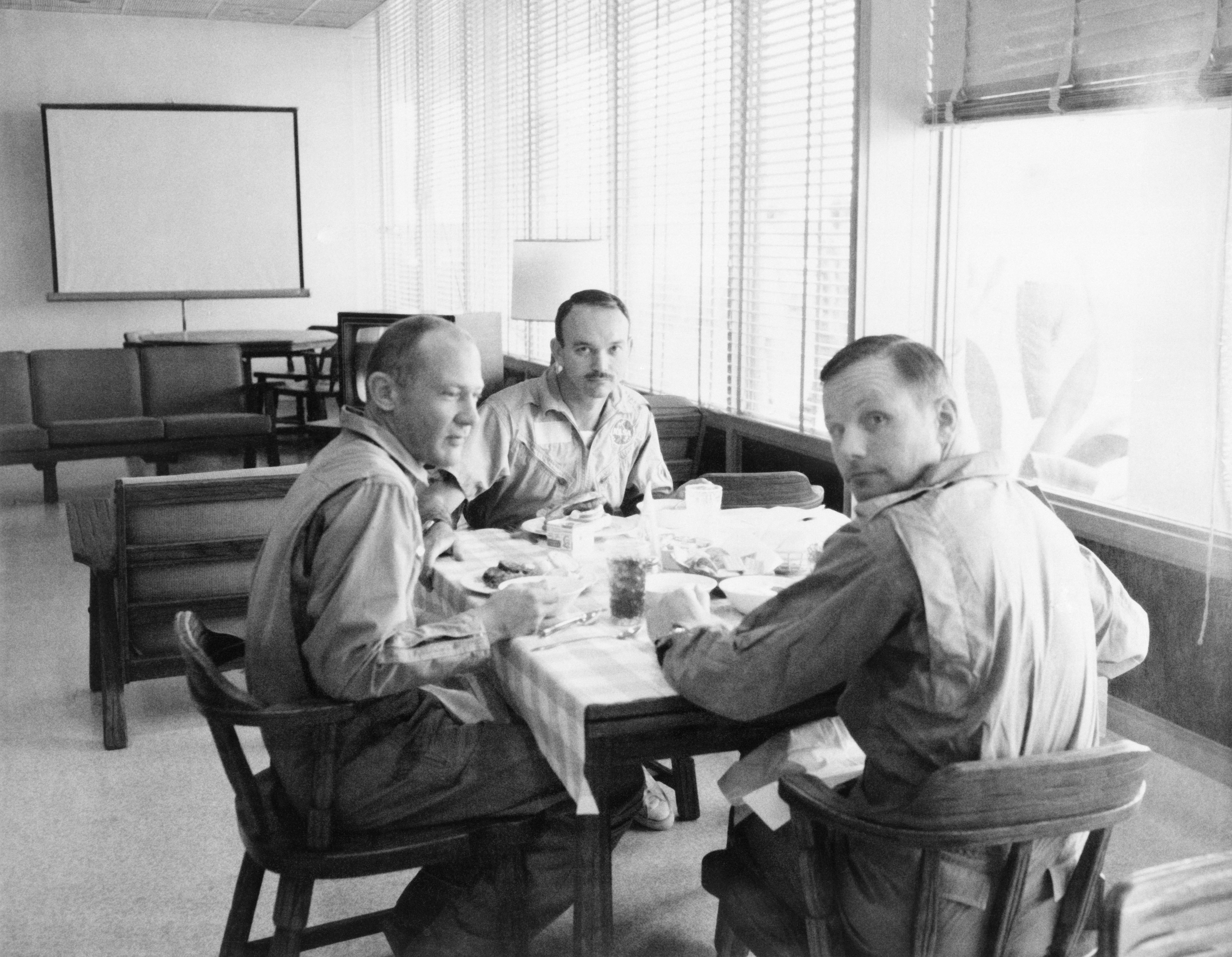 Apollo 11 crewmen dine in an isolate quarantine quarters in the Crew Reception Area of the Lunar Receiving Laboratory of the Manned Spacecraft Center on July 30, 1969.
