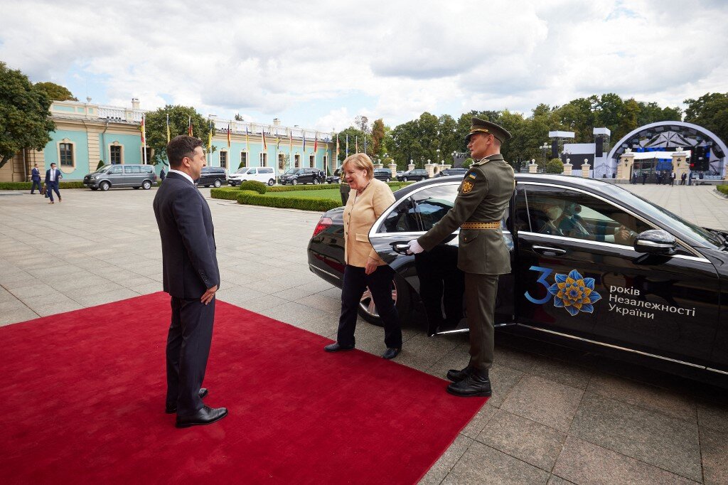 German Chancellor Angela Merkel (C) is welcomed by Ukrainian President Volodymyr Zelensky (L) upon her arival for a meeting at the Mariinsky palace in Kyiv,on August 22, 2021. 