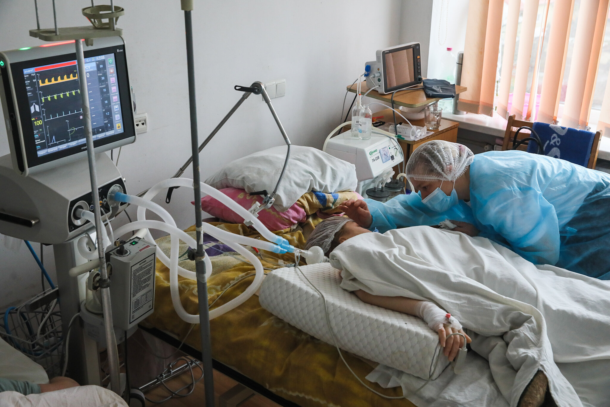 A mother takes care of her daughter infected with coronavirus at Kolomyia District Hospital in Ivano-Frankivsk Oblast on March 16, 2021. She works as a volunteer to be close to her daughter.