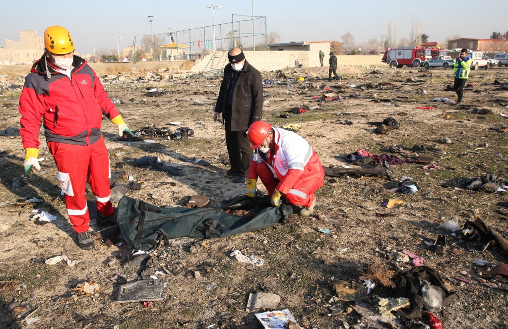 Rescue teams recover a body after a Ukrainian plane carrying 176 passengers crashed near Imam Khomeini airport in the Iranian capital Tehran early in the morning on Jan. 8, 2020, killing everyone on board. The Ukrainian International Airline&#8217;s Boeing 737 was flying from Tehran&#8217;s international airport to Kyiv but crashed 2 minutes after the take-off.