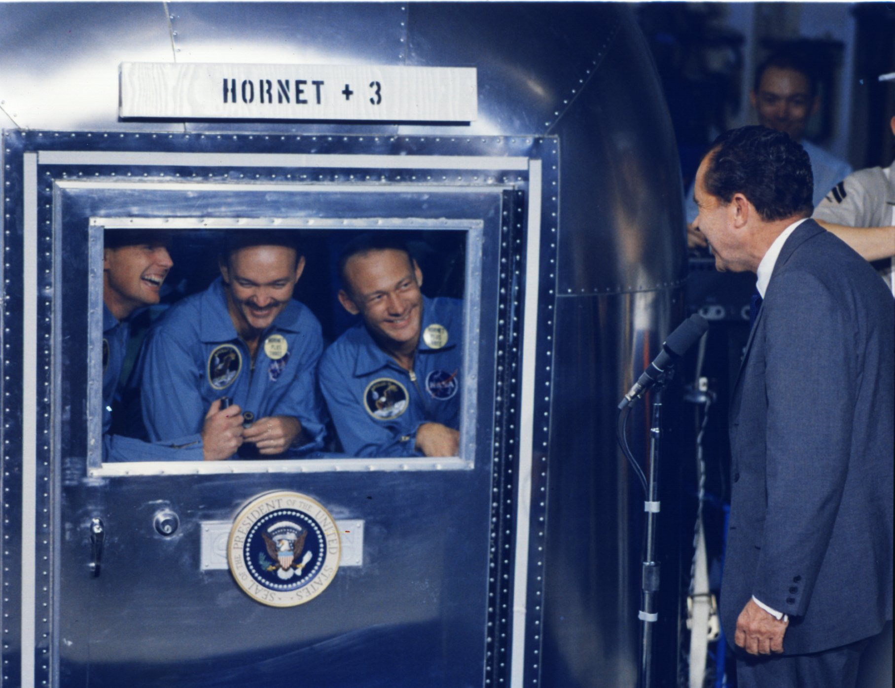 U.S. President Richard M. Nixon greets the Apollo 11 astronauts locked in a biological protection wagon on board of USS Hornet in the Pacific Ocean on July 24, 1969.