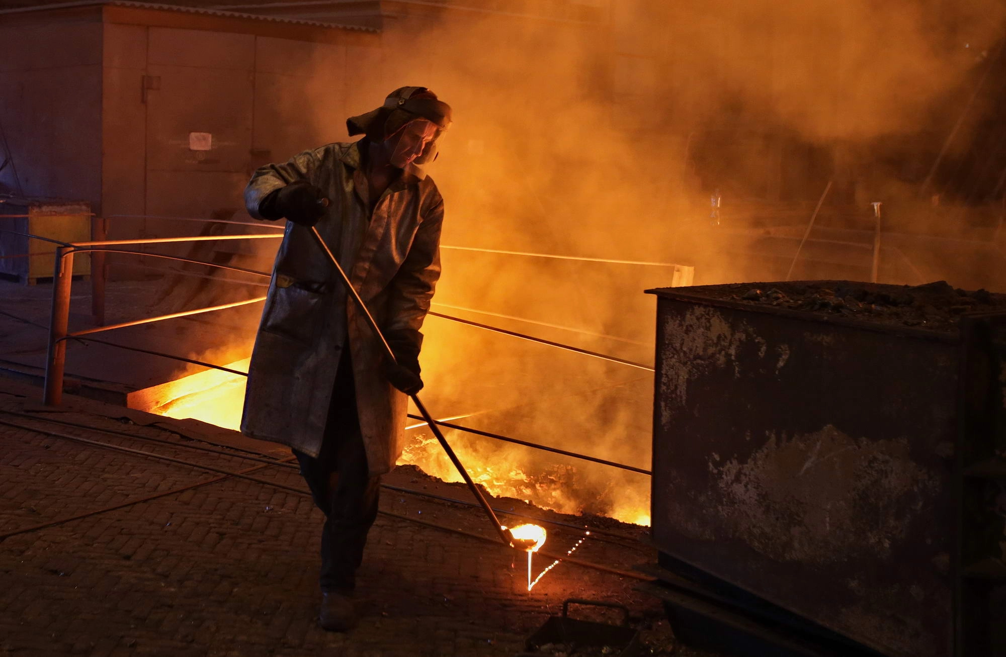 A steelworker inspects a flow of molten steel in a blast furnace at the ArcelorMittal Kryvyi Rih steel plant. 