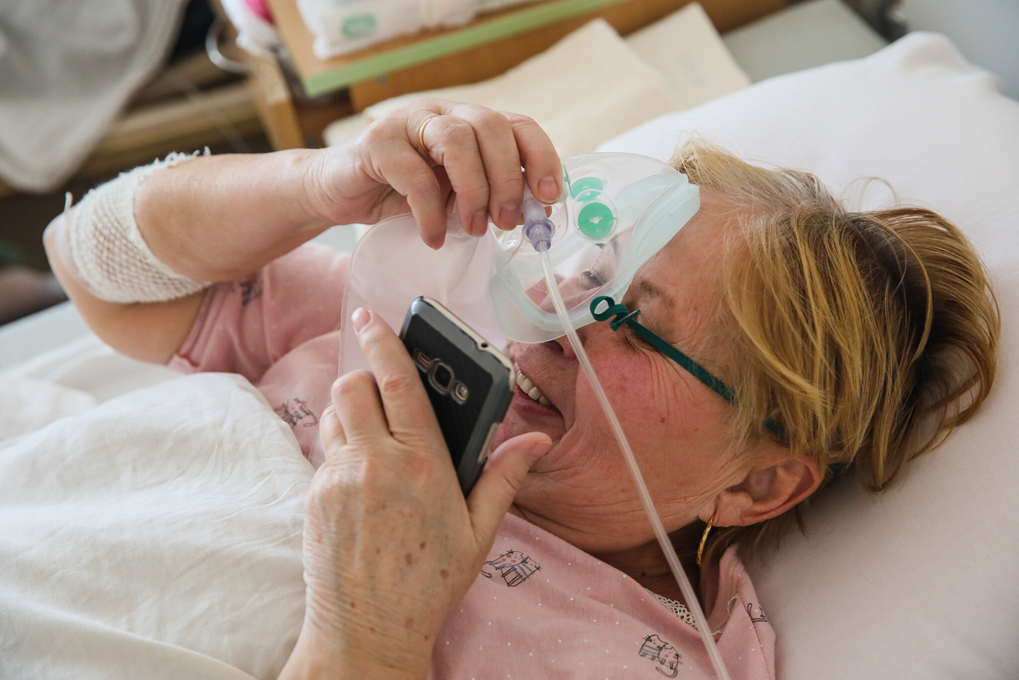 A patient takes her oxygen mask off for a moment while talking on the phone at Kolomyia District Hospital in Ivano-Frankivsk Oblast on March 16, 2021. Some patients can survive no more than several minutes without additional oxygen.