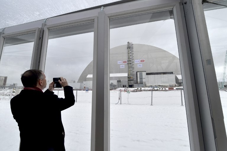 A man takes a picture on November 29, 2016 of the Chornobyl&#8217;s New Safe Confinement.
