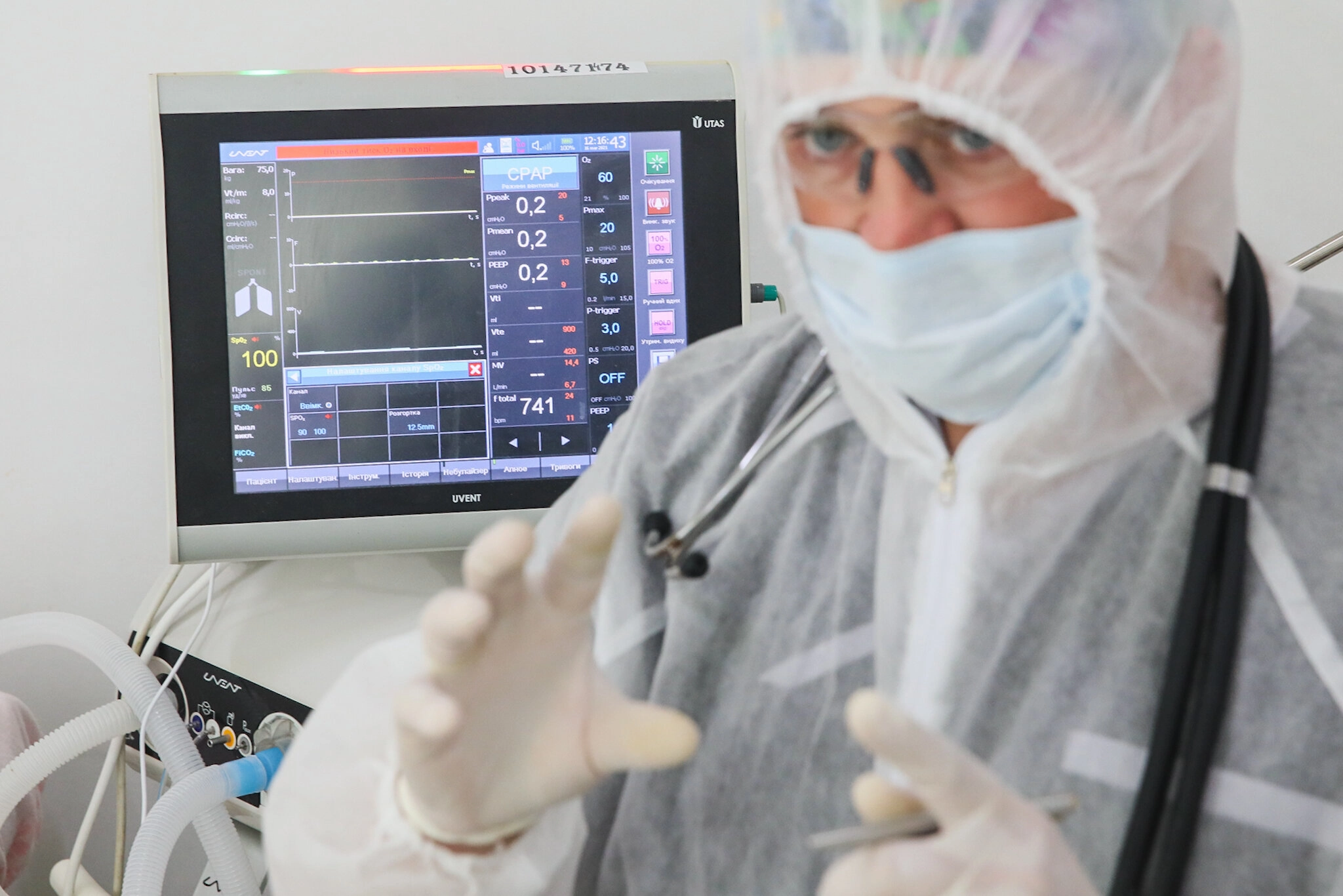 Vitaliy Yakubiyak, an anesthesiologist at Kolomyia District Hospital in Ivano-Frankivsk Oblast, stands next to a CPAP (Continuous Positive Airway Pressure) machine supplying oxygen to his patient on March 16, 2021.