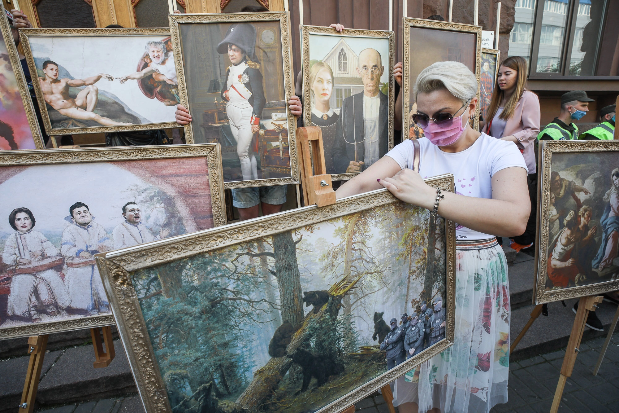 Activists and supporters of European Solidarity political party and Petro Poroshenko hold mockup pictures of classic art masterpieces with the faces of Prosecutor General Iryna Venediktova and President Volodymyr Zelensky during a rally in front of the State Investigation Bureau in downtown Kyiv on June 10, 2020.