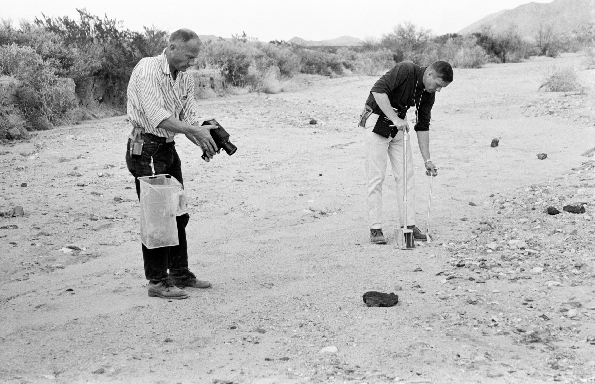 Astronauts Buzz Aldrin (L) and Neil Armstrong (R) take samples of soil in a mountainous area near Houston on Feb. 25, 1969.