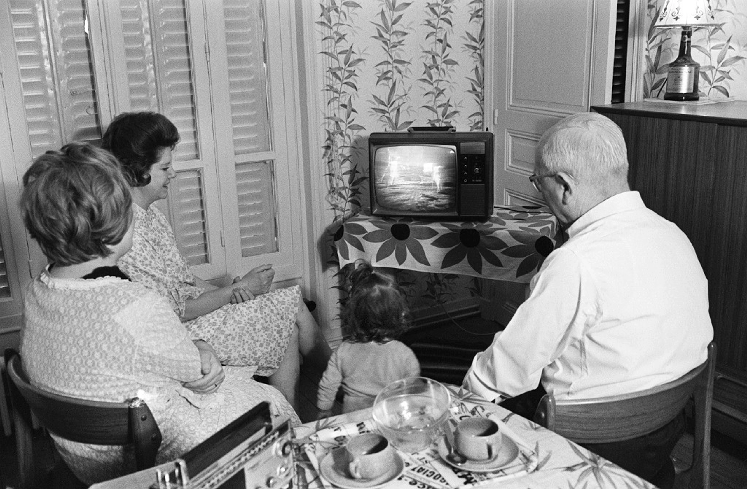 A French family watches the American astronaut Neil Armstrong commander of Apollo 11, setting his foot on the Moon July 21, 1969.