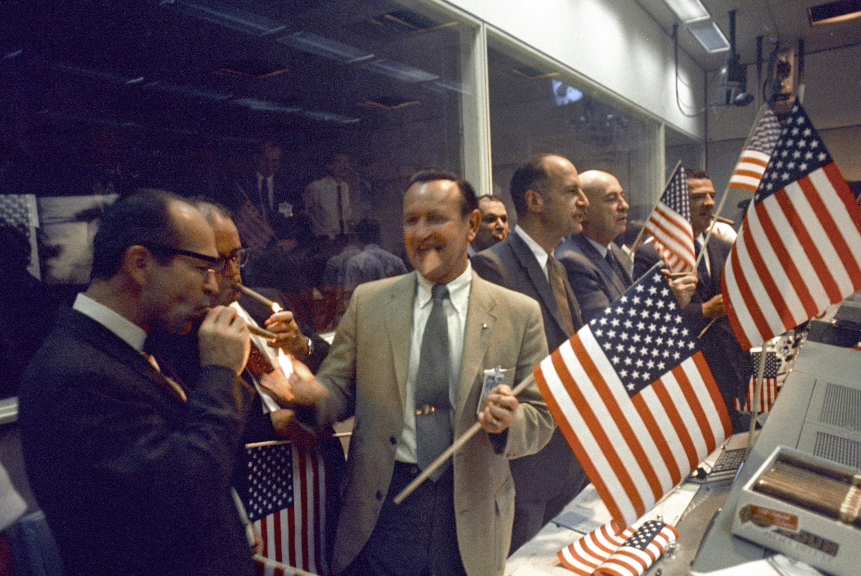 Jubilant NASA personnel  celebrate the Apollo 11 mission accomplishment with traditional cigar smoking at the Mission Control Center in Houston on July 24, 1969.