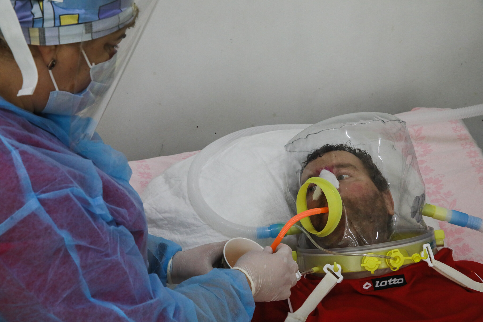 COVID-19 patient Vasyl wears a helmet supplying him with oxygen-enriched air at Kolomyia District Hospital in Ivano-Frankivsk Oblast on March 16, 2021. He used to wear a regular oxygen mask. It had to be replaced with the helmet after his nose began to rot.