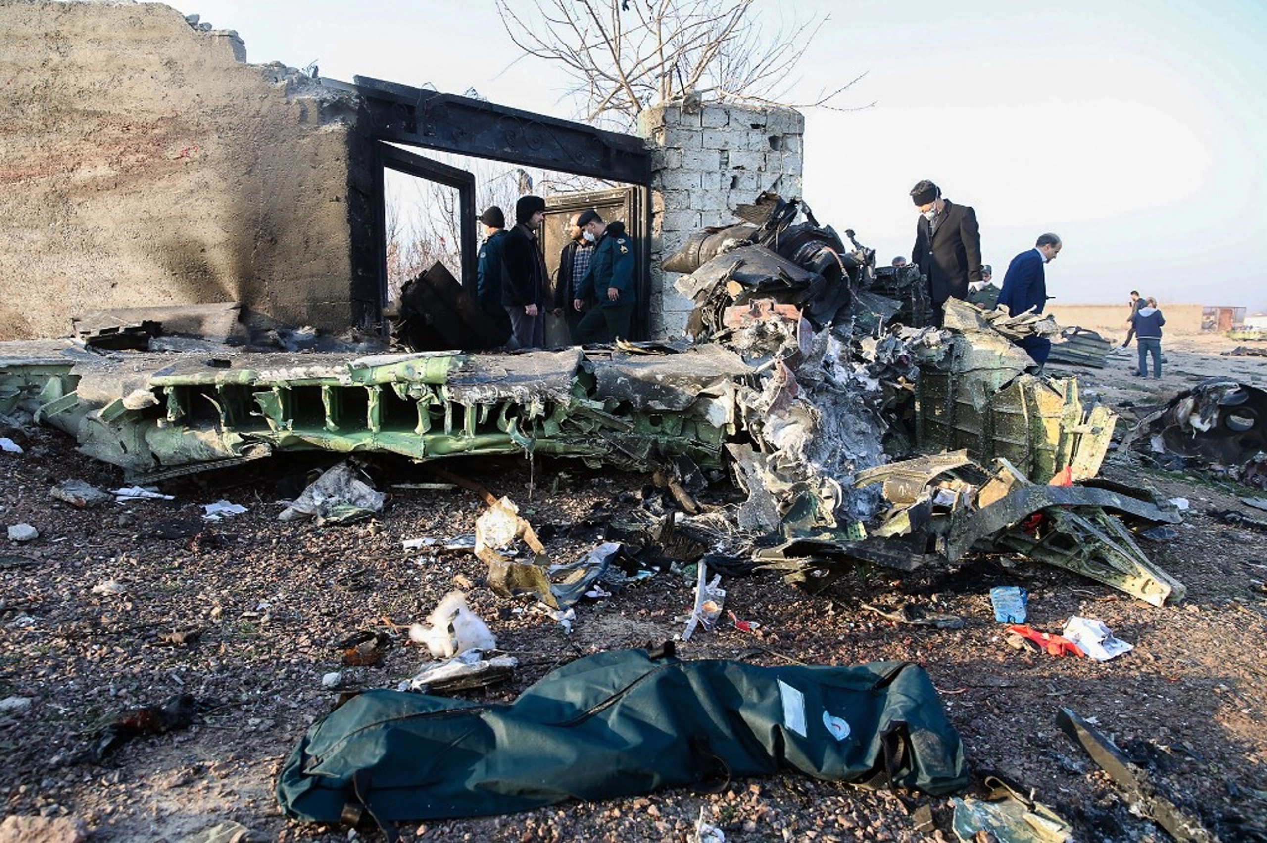 People stand near the wreckage after a Ukrainian plane carrying 176 passengers crashed near Imam Khomeini airport in Tehran on Jan. 8, 2020.