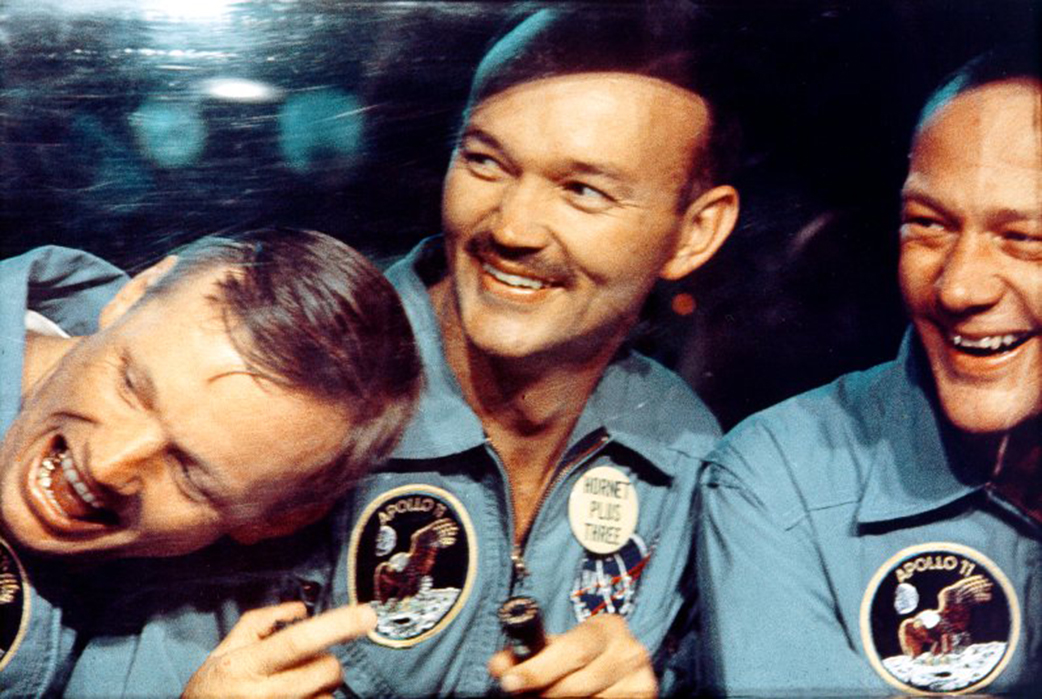 Apollo 11 astronauts laugh inside a biological protection wagon on board of USS Hornet in the Pacific Ocean on July 24, 1969.