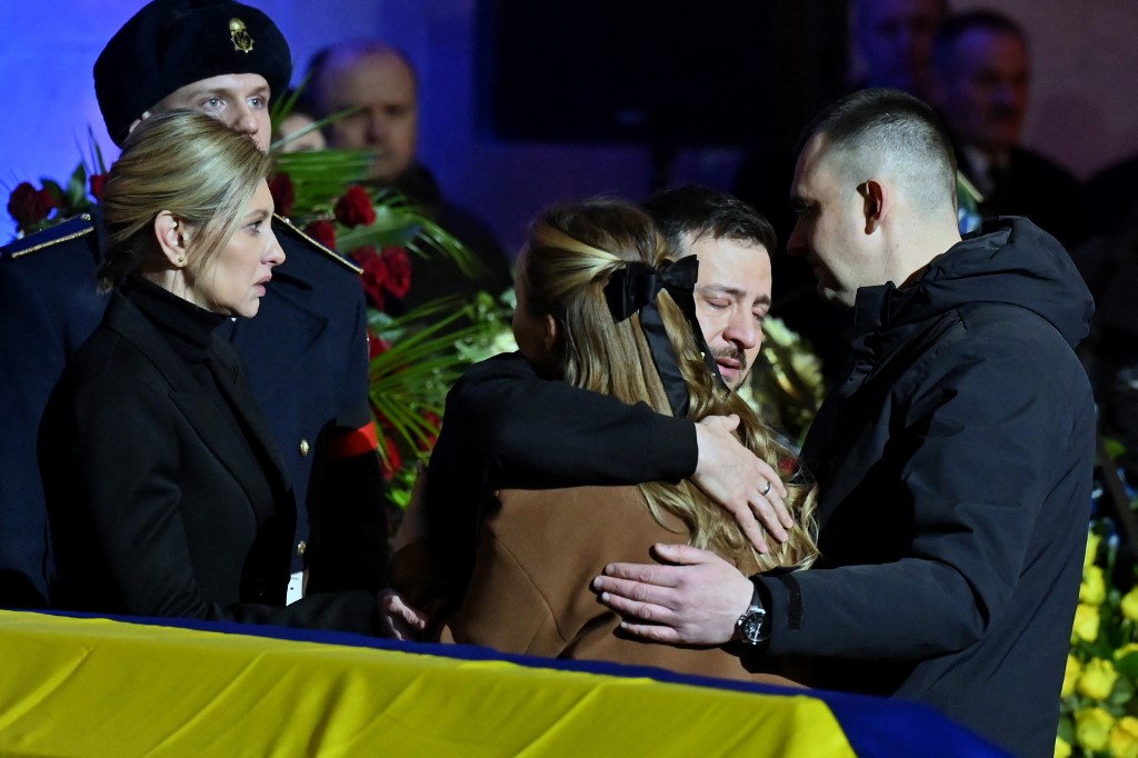 Ukrainian President Volodymyr Zelensky and his wife Olena offer relatives their condolences during the funeral ceremony of Ukrainian Interior Minister Denys Monastyrsky and other employees of his department at the Ukrainian House in Kyiv on January 21, 2023. Sergei SUPINSKY / AFP