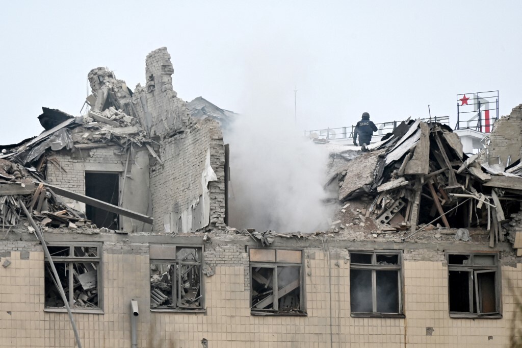This photo taken on February 5, 2023 shows a rescuer on the top of the partially destroyed building of the National University of Urban Economy after a Russian missile strike in Kharkiv, amid the Russian invasion of Ukraine. Sergey BOBOK / AFP