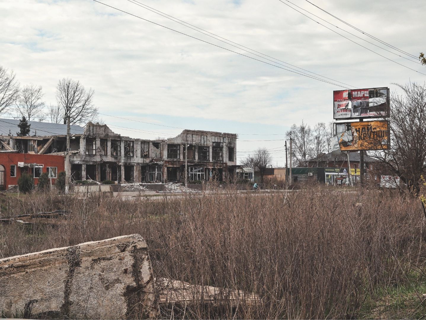 A street north of Kharkiv, where buildings bear the marks of repeated Russian shelling, April 2026. (Photo by Korbinian Leo Kramer)