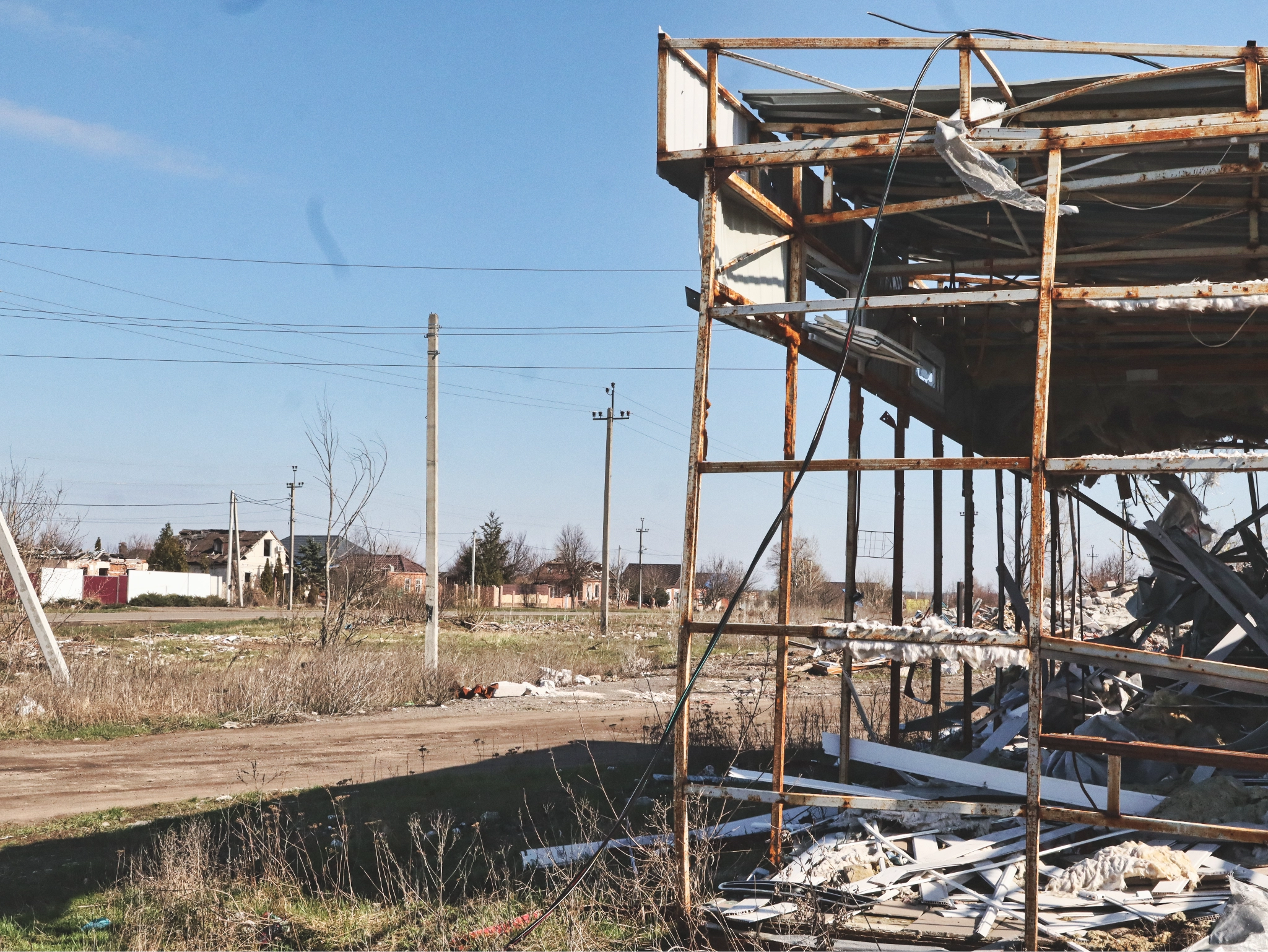 A street north of Kharkiv, where buildings bear the marks of repeated Russian shelling, April 2026. (Photo by Korbinian Leo Kramer)