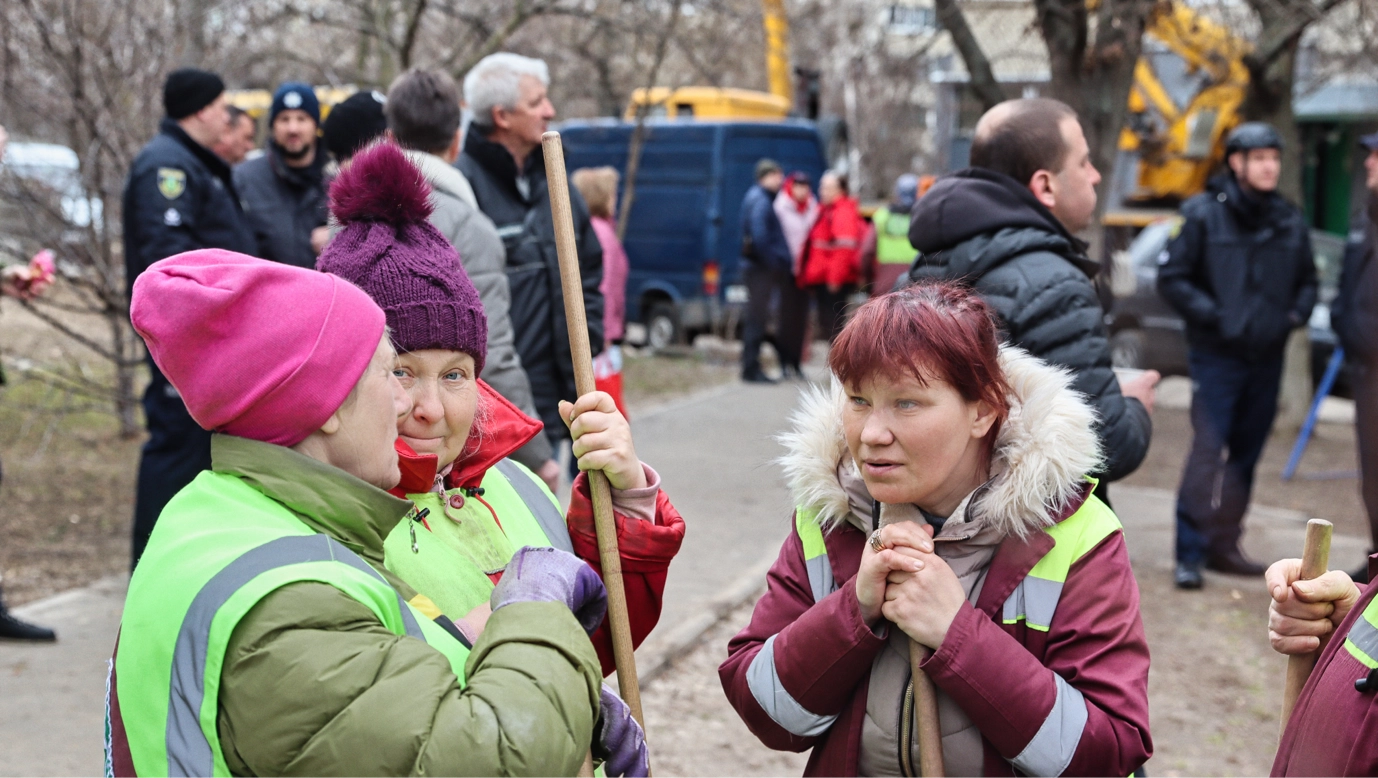 Residents and municipal workers gather in Kharkiv’s Kholodnohirskyi district following a Russian drone strike. Cleanup and repair work began almost immediately after the attack. April 2026 (Photo by Korbinian Leo Kramer)