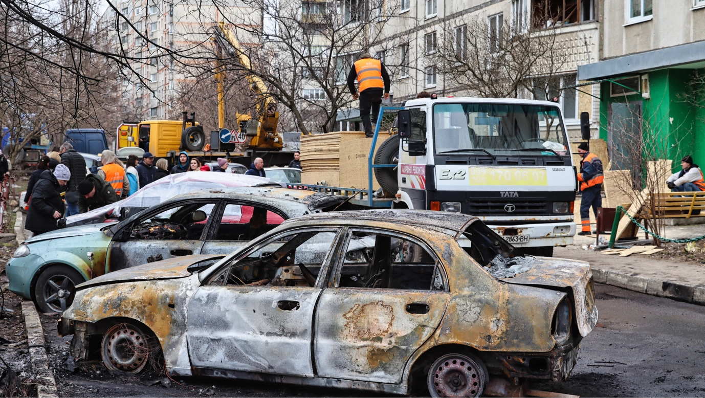 Workers unload wooden OSB boards in Kharkiv’s Kholodnohirskyi district to cover windows shattered by a Russian drone strike earlier that day. April 2026 (Photo by Korbinian Leo Kramer)